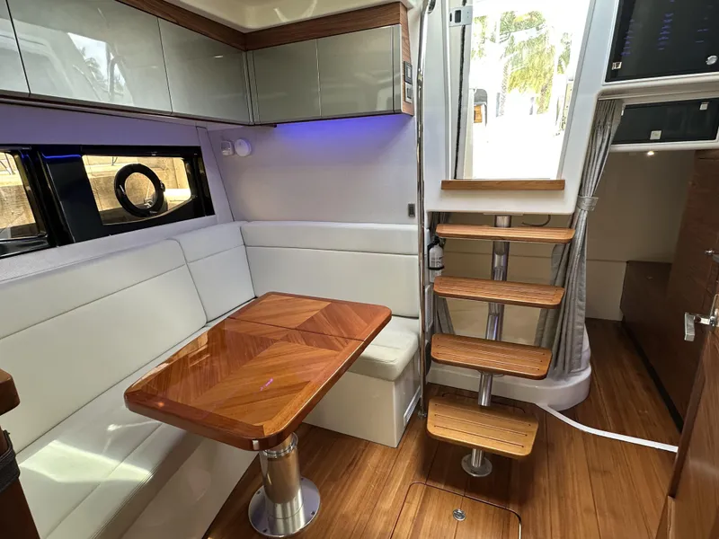 Slide: The Image of Interior of 2022 Boston Whaler 405 Conquest, featuring elegant seating and wooden table. - 11