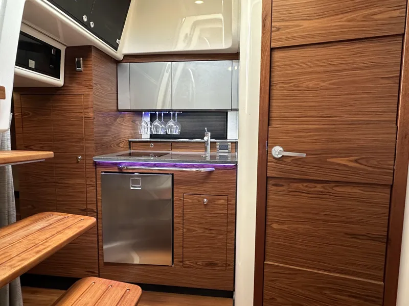 Slide: The Image of 2022 Boston Whaler 405 Conquest interior with modern kitchen and wooden cabinetry. - 12