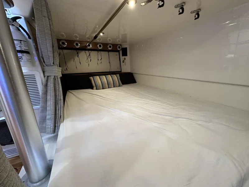 Slide: The Image of Interior cabin of 2022 Boston Whaler 405 Conquest with cozy bed and striped pillow. - 15