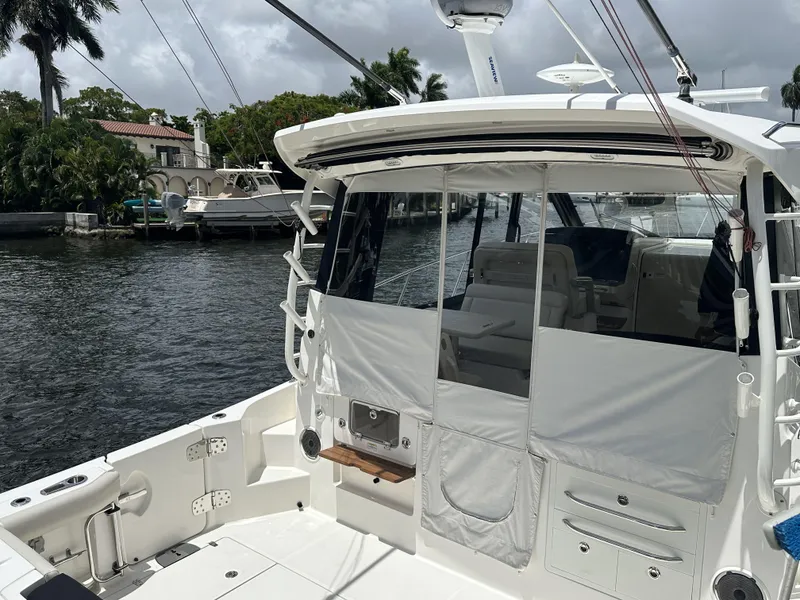 Slide: The Image of 2022 Boston Whaler 405 Conquest boat docked by a waterfront, showcasing its spacious deck. - 19