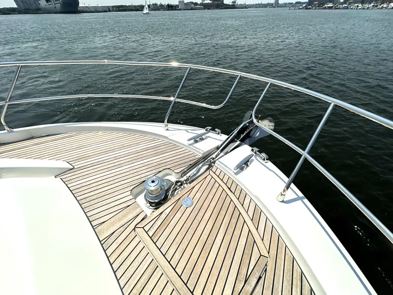 Slide: The Image of Bow of 2022 Prestige 520 yacht with teak decking on calm water. - 12