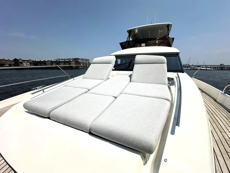 Slide: The Image of Luxury 2022 Prestige 520 yacht with sun loungers on deck, docked by waterfront. - 13