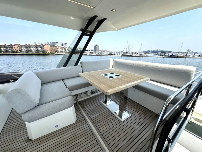 Slide: The Image of Luxurious 2022 Prestige 520 yacht deck with elegant seating and table, overlooking marina. - 16