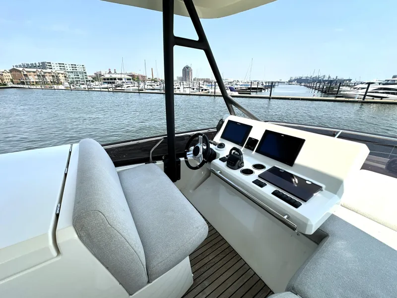 Slide: The Image of Helm of 2022 Prestige 520 yacht with modern controls, overlooking marina. - 22