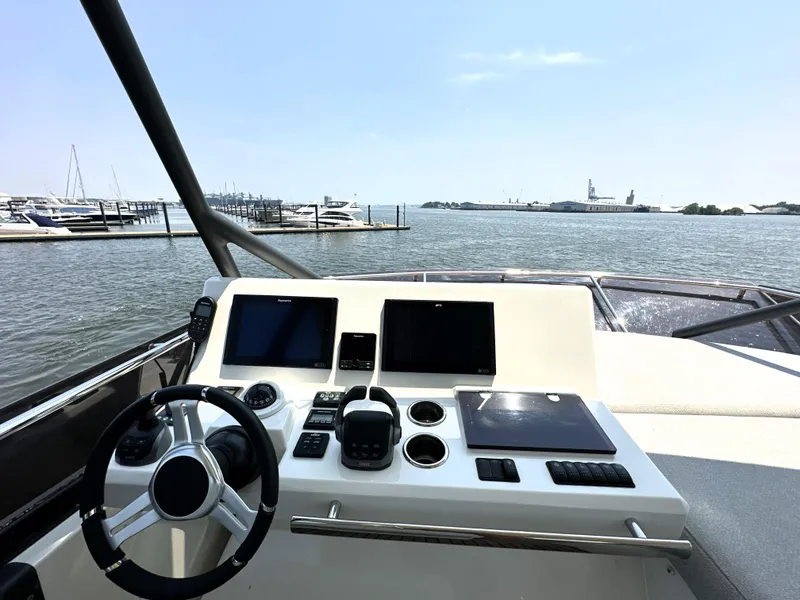 Slide: The Image of Helm of 2022 Prestige 520 yacht with modern controls, overlooking marina and water. - 23