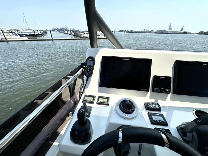 Slide: The Image of Helm of 2022 Prestige 520 yacht with navigation controls and waterfront view. - 24