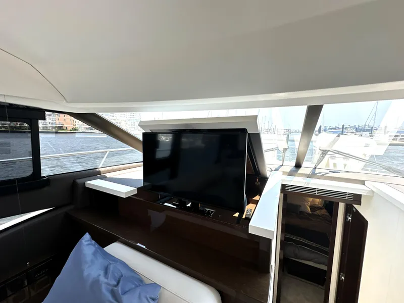 Slide: The Image of Luxurious interior of 2022 Prestige 520 yacht with retractable TV and waterfront view. - 35