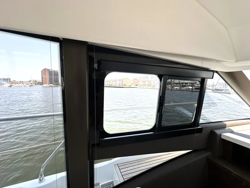 Slide: The Image of Interior view from a 2022 Prestige 520 yacht, showcasing water and cityscape through windows. - 40