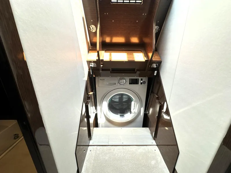 Slide: The Image of Laundry area with a washing machine inside a 2022 Prestige 520 yacht. - 48