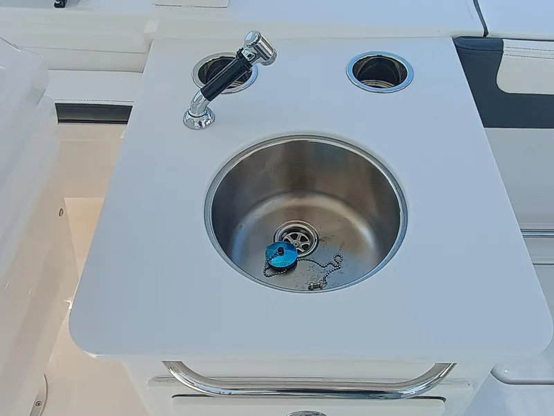 Slide: The Image of 2025 Robalo R257 Dual Console boat sink with faucet and drain plug. - 10
