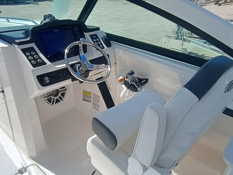 Slide: The Image of 2025 Robalo R257 Dual Console boat interior with steering wheel and control panel. - 11