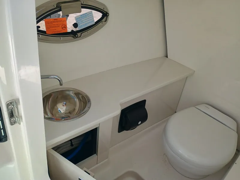 Slide: The Image of 2025 Robalo R257 Dual Console boat interior with sink and toilet. - 27