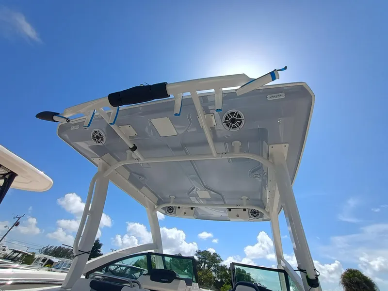 Slide: The Image of 2025 Robalo R257 Dual Console boat with T-top under clear blue sky. - 38