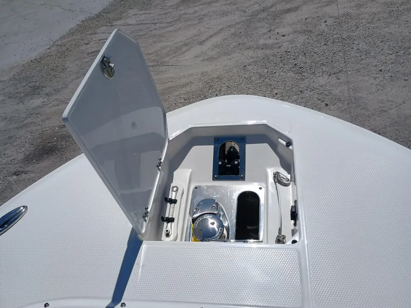 Slide: The Image of 2025 Robalo R257 Dual Console anchor compartment with open hatch on a textured deck. - 41