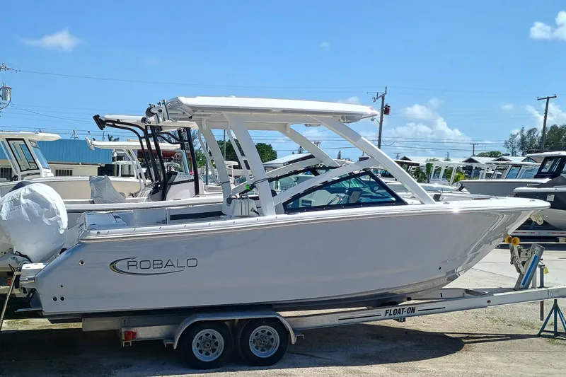 Slide: The Image of 2025 Robalo R257 Dual Console boat on trailer, side view, sunny day. - 43