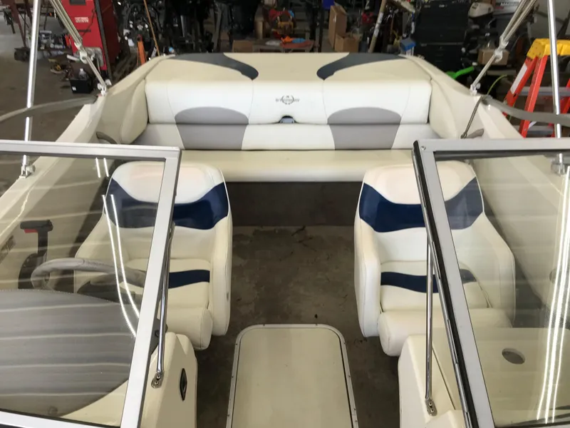 Slide: The Image of 2012 Stingray 195 RX boat interior with white and blue seating, dual consoles, and open cockpit. - 10