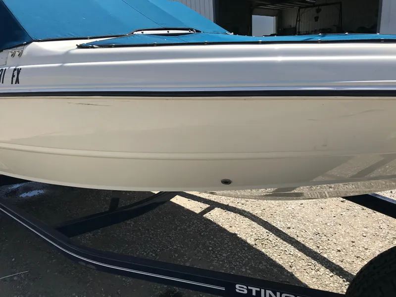 Slide: The Image of 2012 Stingray 195 RX boat with blue cover on trailer. - 6
