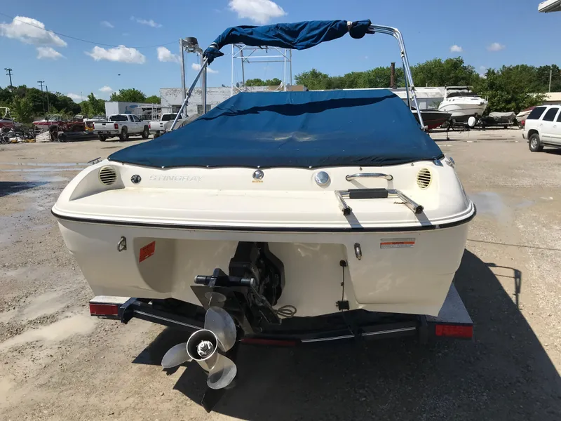Slide: The Image of 2012 Stingray 195 RX boat with blue cover, parked outdoors. - 7