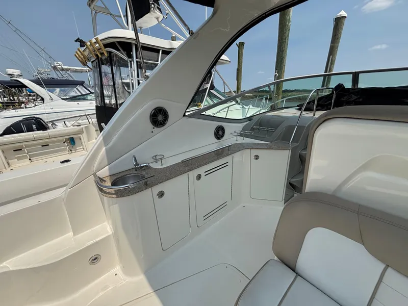 Slide: The Image of 2014 Sea Ray 330 Sundancer interior with seating and cabinetry, docked at marina. - 10