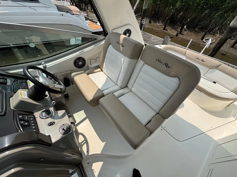 Slide: The Image of 2014 Sea Ray 330 Sundancer cockpit with dual seats and steering console. - 11
