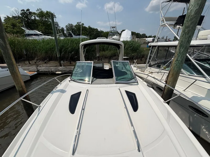 Slide: The Image of 2014 Sea Ray 330 Sundancer docked, showcasing sleek design and spacious deck. - 16