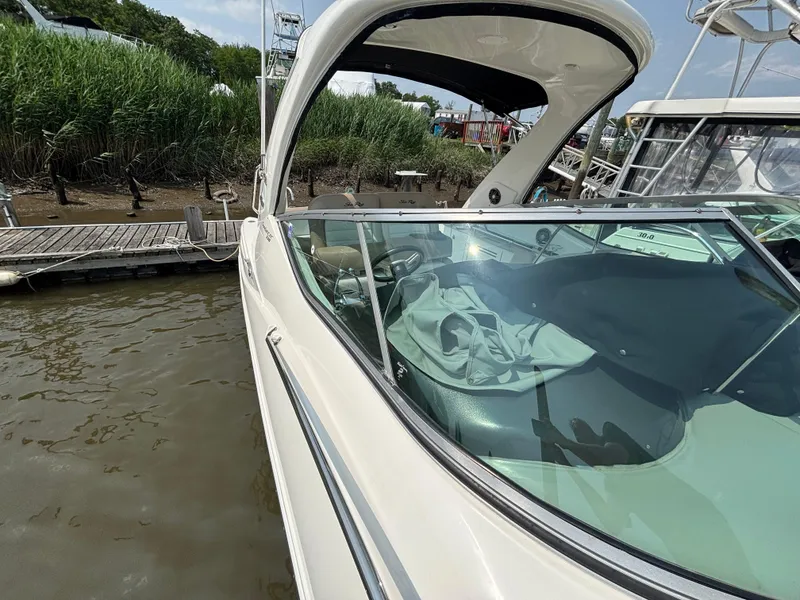 Slide: The Image of 2014 Sea Ray 330 Sundancer docked, showcasing sleek design and spacious cockpit. - 18