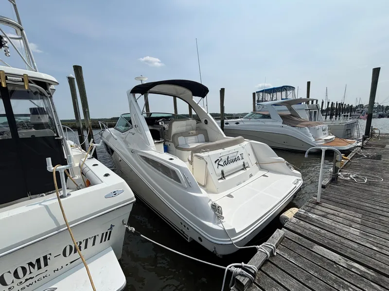 Slide: The Image of 2014 Sea Ray 330 Sundancer docked at marina, surrounded by other boats. - 2