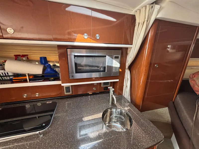 Slide: The Image of Interior of 2014 Sea Ray 330 Sundancer with kitchenette, microwave, and sink. - 22