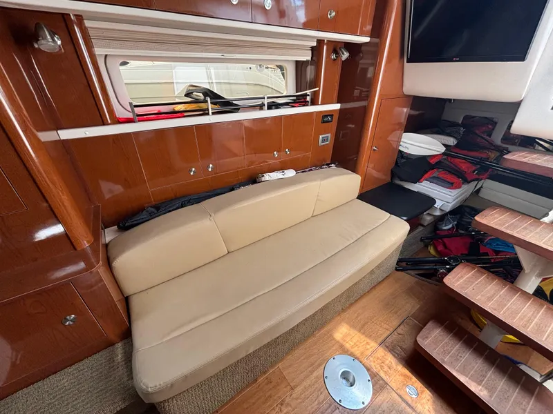 Slide: The Image of Interior of 2014 Sea Ray 330 Sundancer with beige seating and wooden accents. - 23