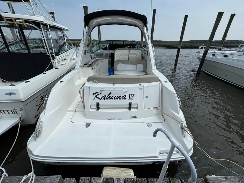 Slide: The Image of 2014 Sea Ray 330 Sundancer docked, rear view with "Kahuna IV" nameplate. - 3