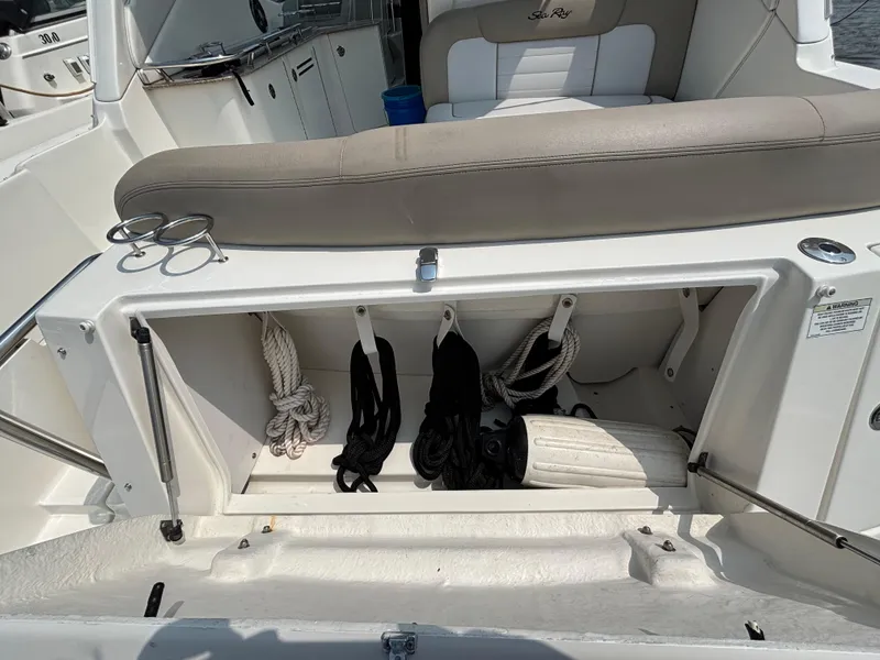 Slide: The Image of 2014 Sea Ray 330 Sundancer boat storage compartment with ropes and accessories. - 6