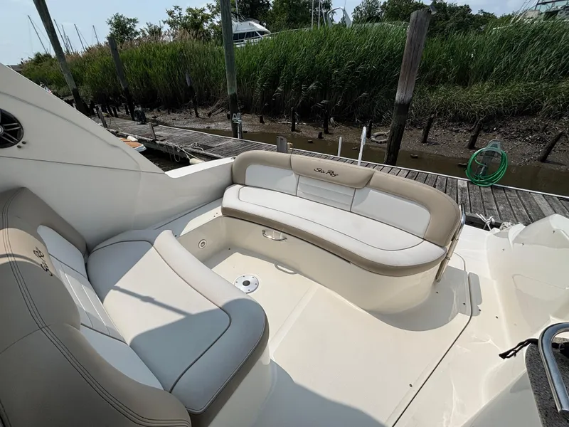 Slide: The Image of 2014 Sea Ray 330 Sundancer boat with beige seating, docked near lush greenery. - 7