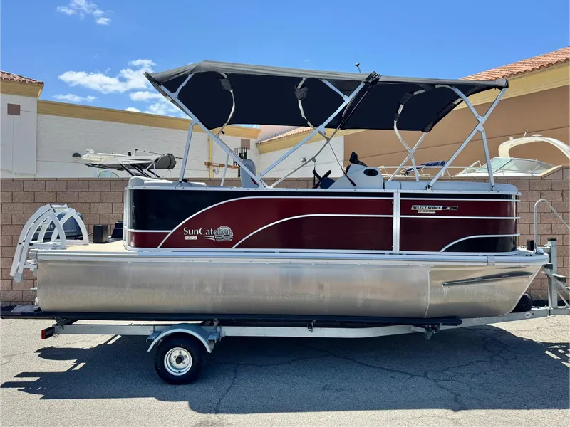 Slide: The Image of 2021 SunCatcher Select 18C pontoon boat on trailer, featuring a sleek design and canopy. - 1