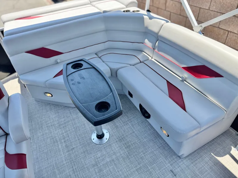 Slide: The Image of 2021 SunCatcher Select 18C boat interior with gray and red seating, and a central table. - 15