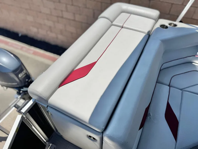 Slide: The Image of SunCatcher Select 18C 2021 boat seat with red accents and motor in background. - 16