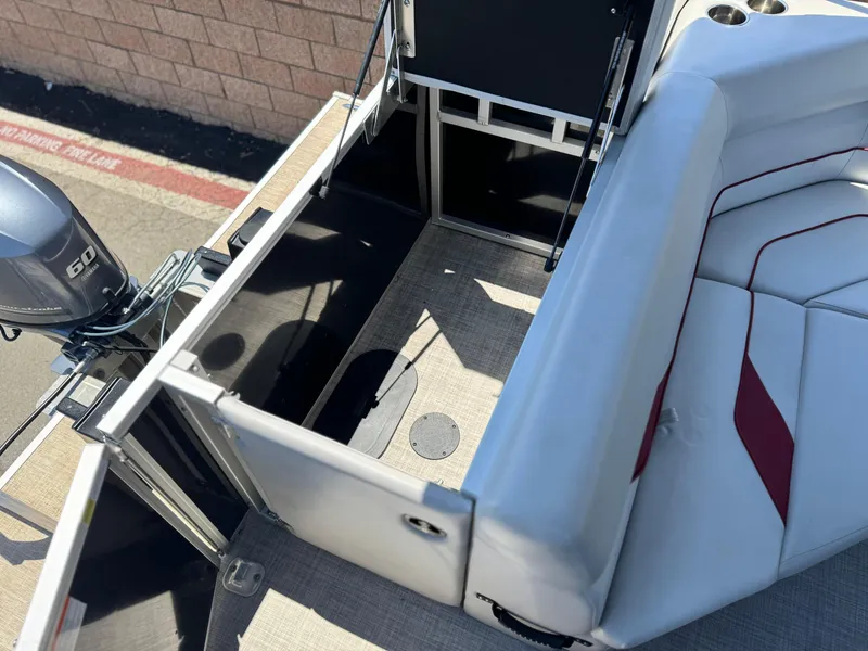 Slide: The Image of 2021 SunCatcher Select 18C pontoon boat interior with seating and motor view. - 17