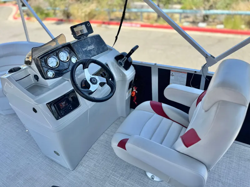 Slide: The Image of 2021 SunCatcher Select 18C boat cockpit with steering wheel and control panel. - 19