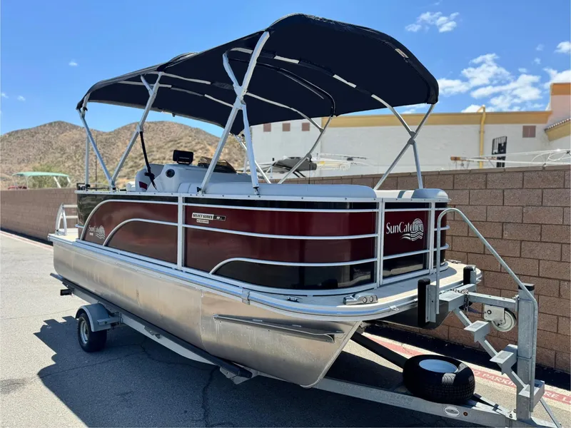 Slide: The Image of 2021 SunCatcher Select 18C pontoon boat on trailer, parked outdoors. - 2