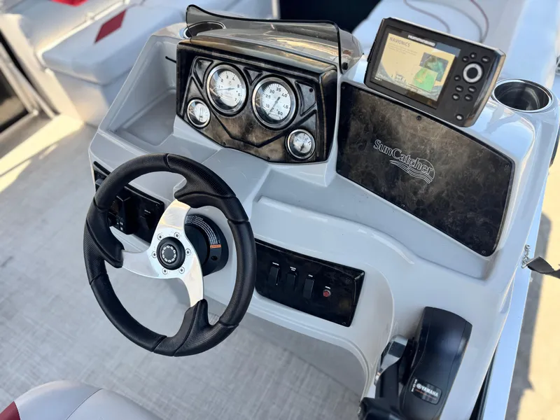 Slide: The Image of 2021 SunCatcher Select 18C boat dashboard with steering wheel and navigation system. - 21