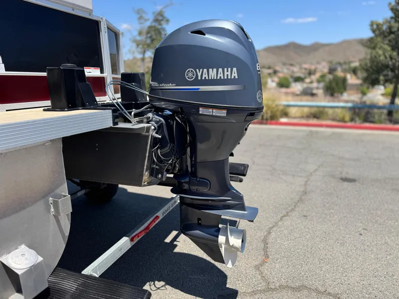 Slide: The Image of Outboard motor on a 2021 SunCatcher Select 18C boat, parked outdoors. - 7