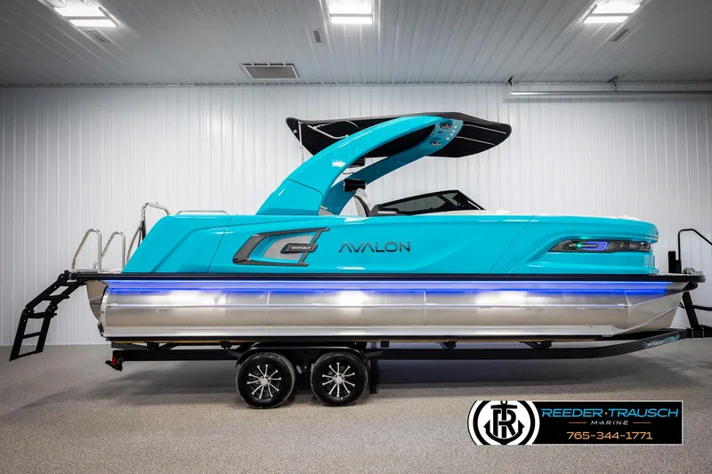 Slide: The Image of 2025 Avalon 2585 Excal VRBW pontoon boat in a showroom, vibrant blue color. - 5
