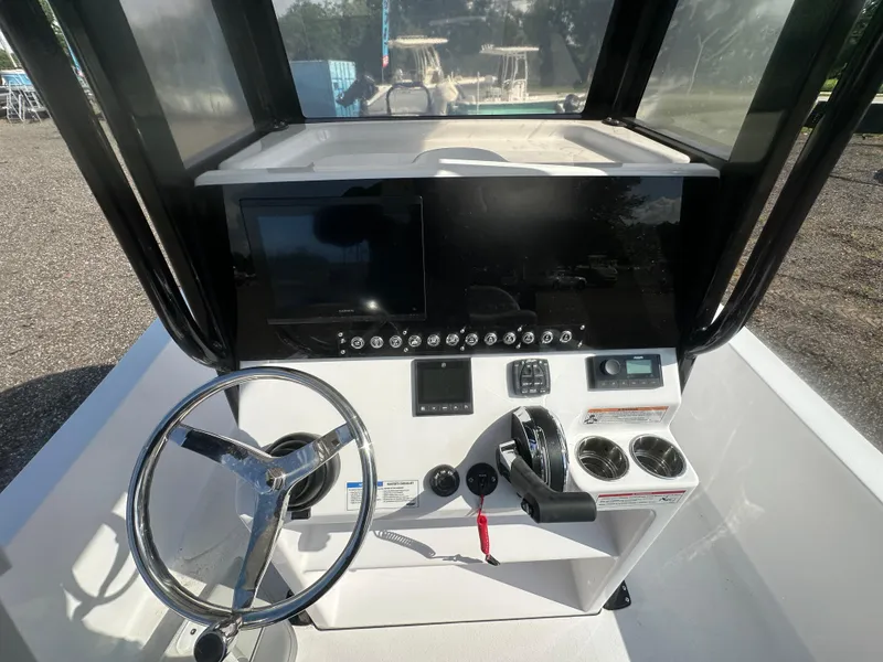 Slide: The Image of 2026 Action Craft 24 Bay boat dashboard with steering wheel and control panel. - 21