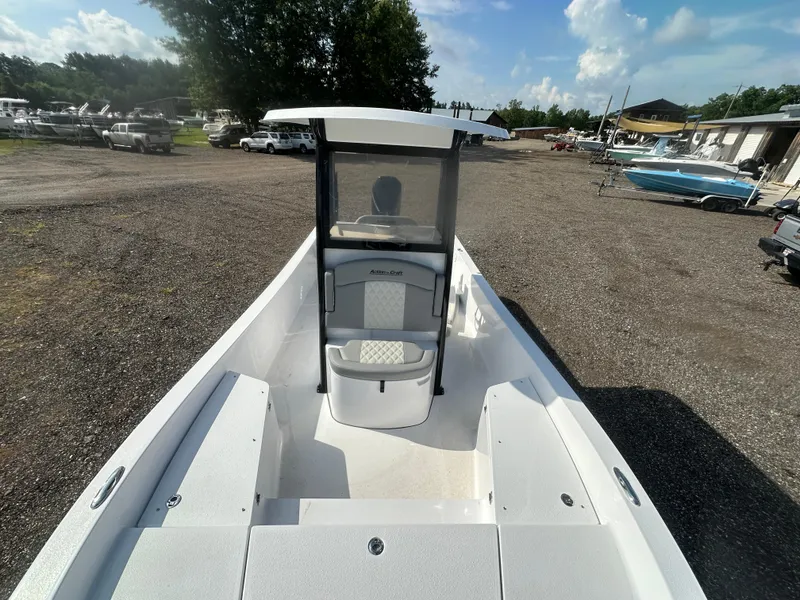 Slide: The Image of 2026 Action Craft 24 Bay boat in a marina, showcasing sleek design and spacious deck. - 24