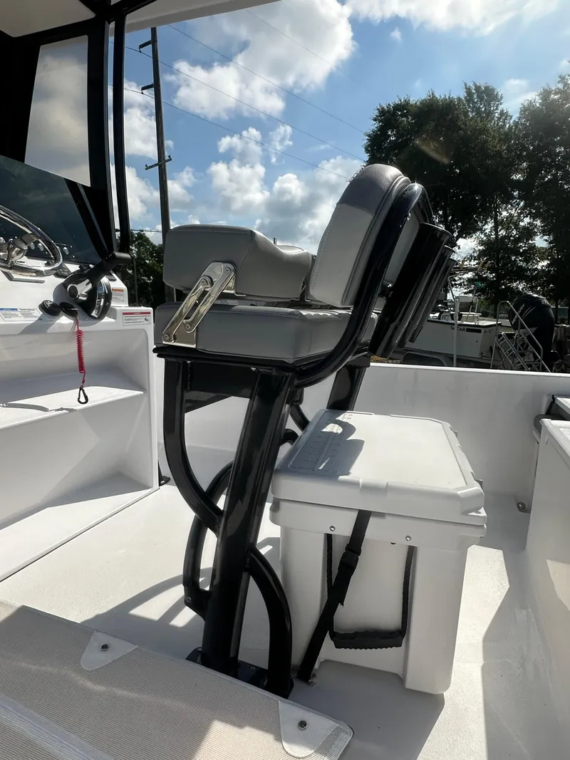 Slide: The Image of 2026 Action Craft 24 Bay boat interior with seating and console under a sunny sky. - 17