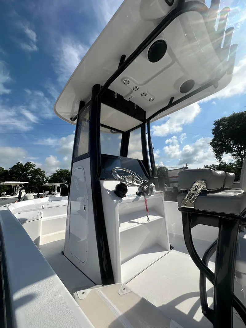 Slide: The Image of 2026 Action Craft 24 Bay boat console under a clear blue sky. - 18