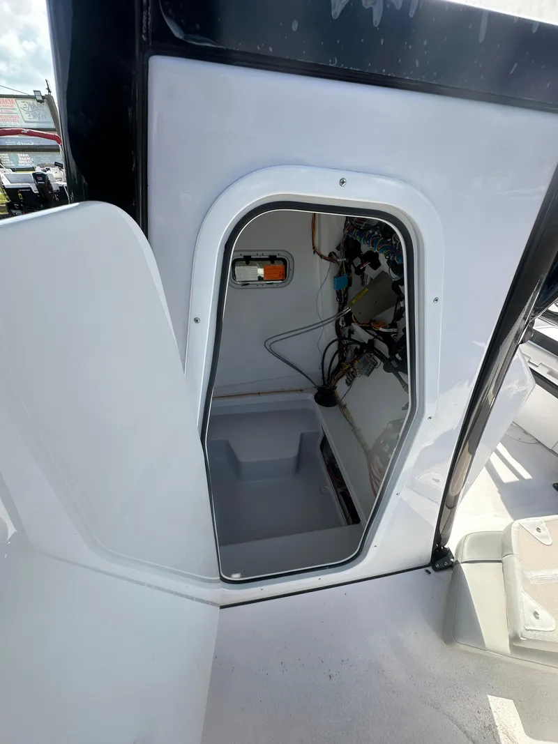 Slide: The Image of 2026 Action Craft 24 Bay boat interior compartment with wiring and storage space. - 26