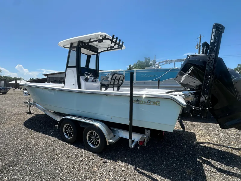 Slide: The Image of 2026 Action Craft 24 Bay boat on trailer, featuring a Mercury engine, parked outdoors. - 3