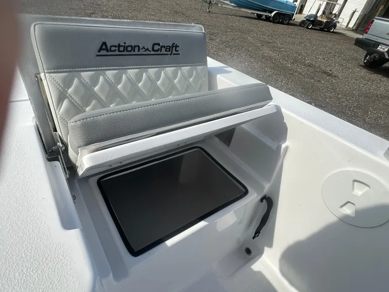 Slide: The Image of 2026 Action Craft 24 Bay boat seat with storage compartment, outdoor setting. - 35