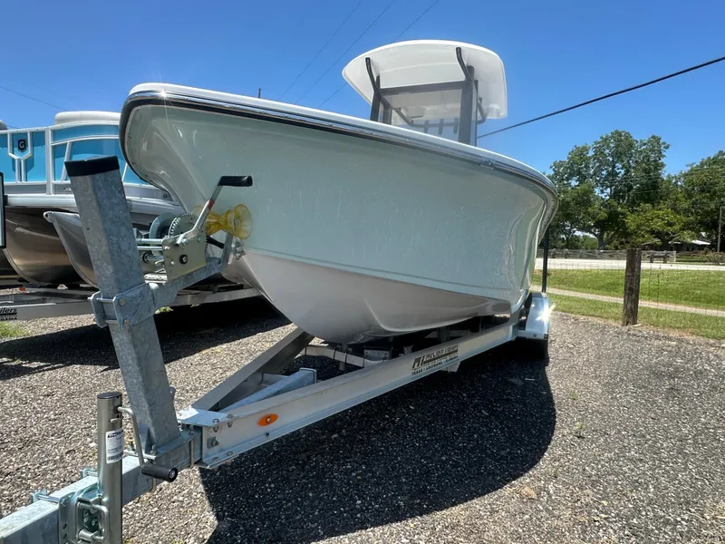 Slide: The Image of 2026 Action Craft 24 Bay boat on trailer under clear blue sky. - 4