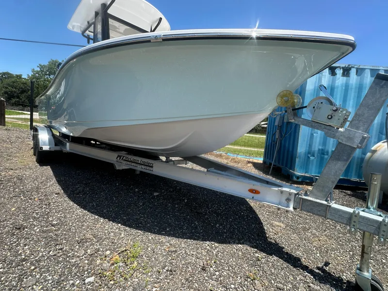 Slide: The Image of 2026 Action Craft 24 Bay boat on trailer under clear blue sky. - 5